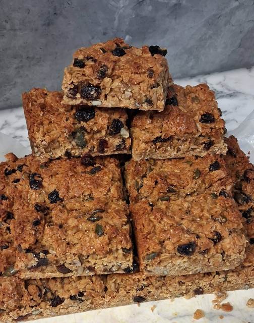 A stack of flapjack squares with dried fruit and seeds